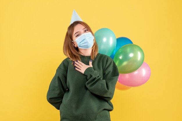 Front view young female holding colorful balloons