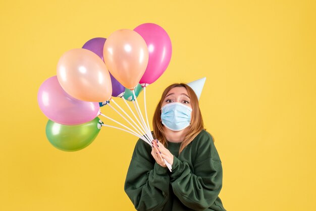 Front view young female holding colorful balloons