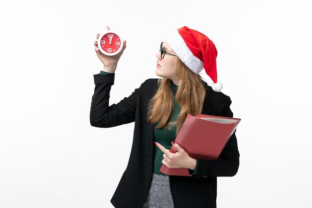 Front view young female holding files and clock on white wall book lesson college