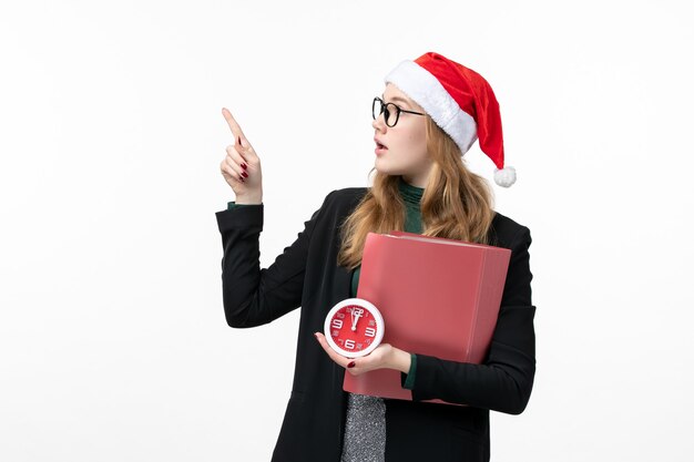 Front view young female holding files and clock on a white wall book lessons college