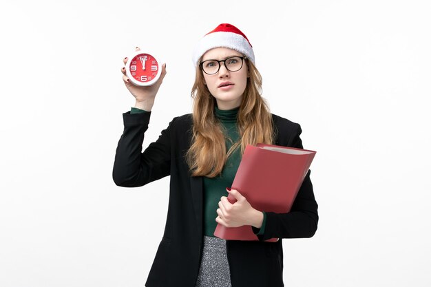 Front view young female holding files and clock on white wall books new year christmas