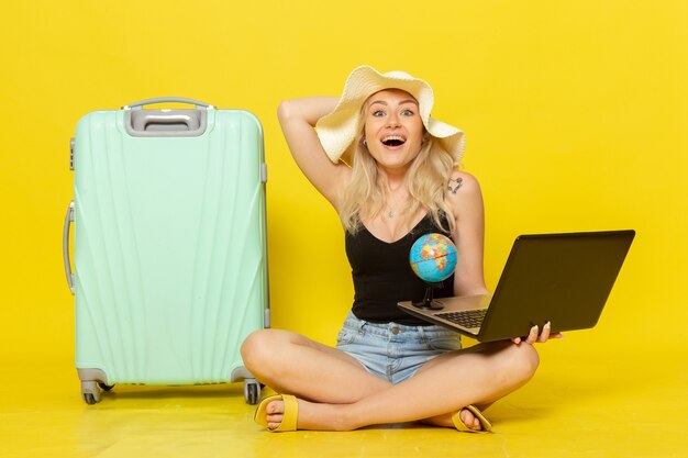 Front view young female holding her laptop and globe