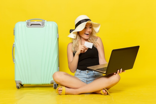 Front view young female holding her laptop and white card