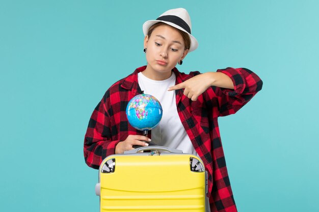 Front view young female holding little globe on blue space