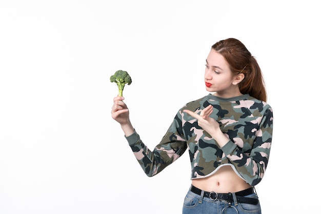 흰색 배경에 작은 녹색 브로콜리를 들고 전면 보기 젊은 여성 몸 다이어트 식사 건강 식품 수평 점심 샐러드