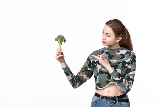 Front view young female holding little green broccoli on white background body diet meal health food horizontal lunch salad