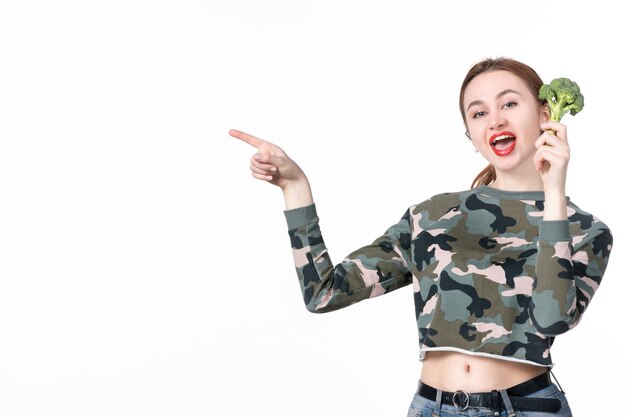 Front view young female holding little green broccoli on white background dish lunch body horizontal salad meal diet food