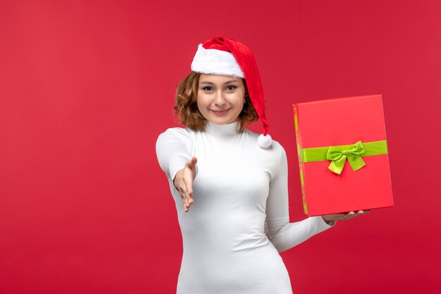 Front view of young female holding present on red