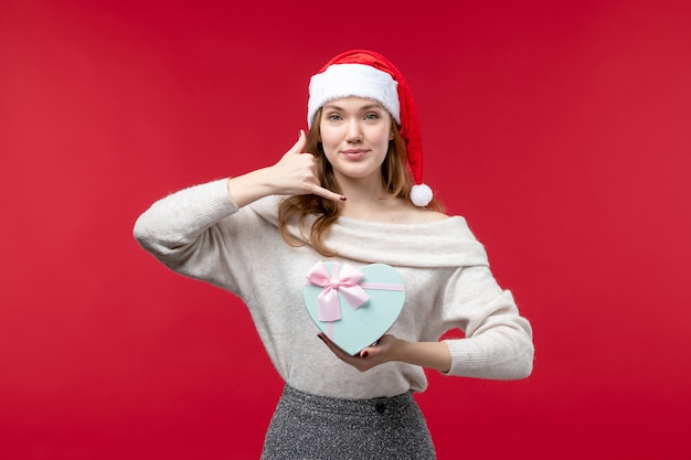 Free photo front view of young female holding present on red