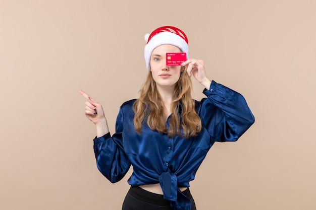 Front view young female holding red bank card on pink background holiday xmas money photos new year emotion