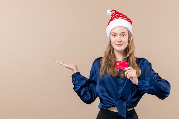 Front view young female holding red bank card on pink background money holiday photo new year xmas emotions
