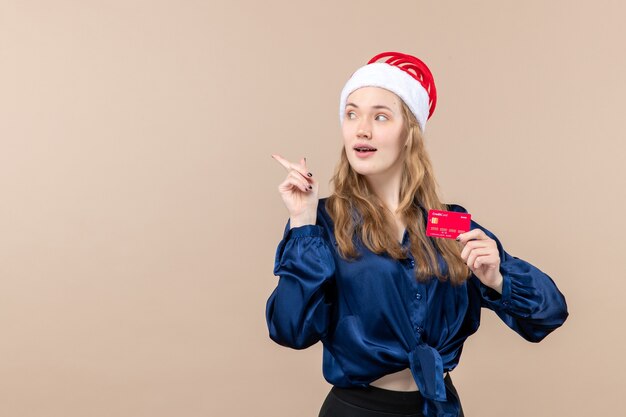 Front view young female holding red bank card on pink background money holidays photo new year xmas emotions free place