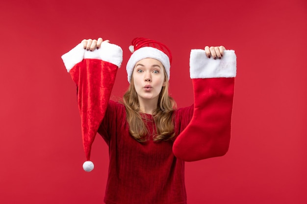 Free photo front view young female holding red big sock and cap, holidays red christmas