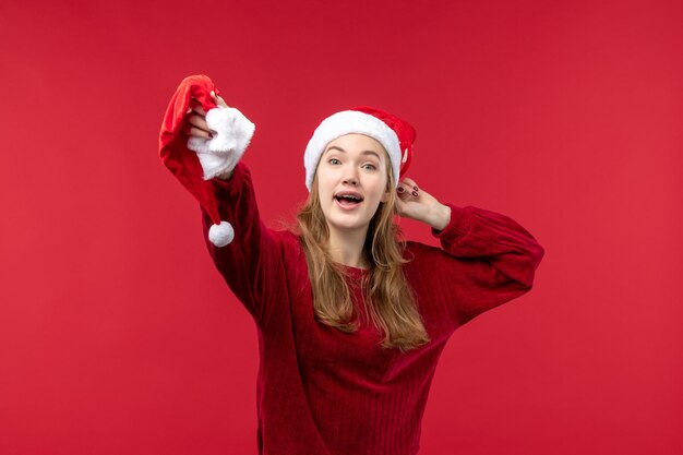 Front view young female holding red cap, christmas holiday christmas