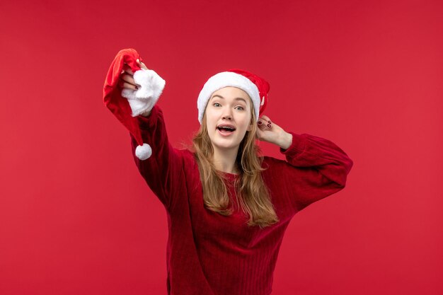 正面図赤い帽子を保持している若い女性、クリスマス休暇クリスマス