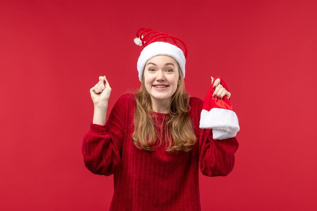 Front view young female holding red cap, holiday christmas emotion