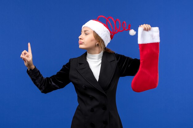 Front view young female holding red christmas sock on blue desk human holidays new year