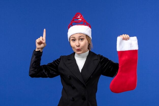 Front view young female holding red christmas sock on a blue wall human new year holiday