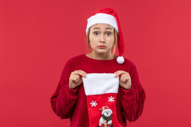 Вид спереди молодая женщина держит красный рождественский носок, красный праздник Рождества