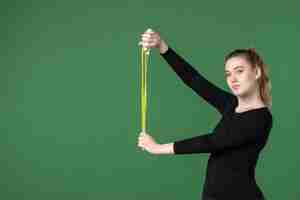 Free photo front view young female holding skipping rope on green background color sport athlete yoga health body woman gymnastics