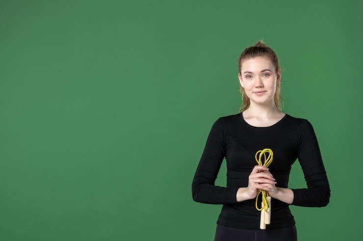 Бесплатный Фотография вид спереди молодая женщина, держащая скакалку на зеленом фоне, здоровье женщины, тренировка, цвет, спортивная гимнастика, тело