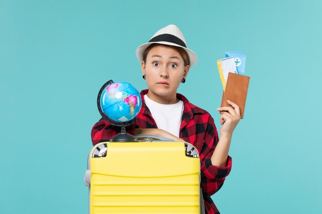 Front view young female holding tickets on blue desk