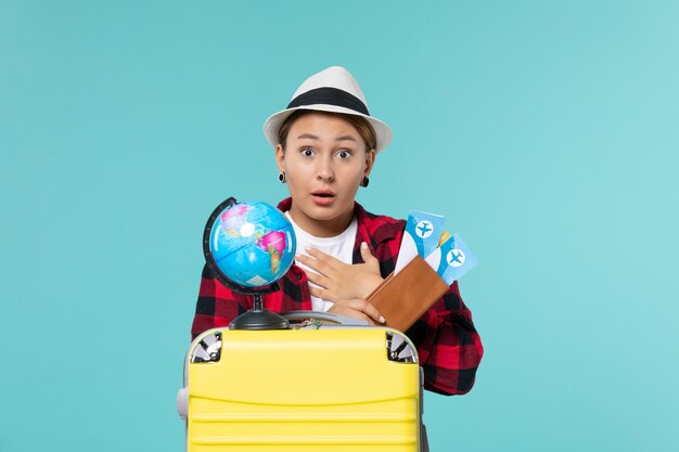 Front view young female holding tickets on a blue space