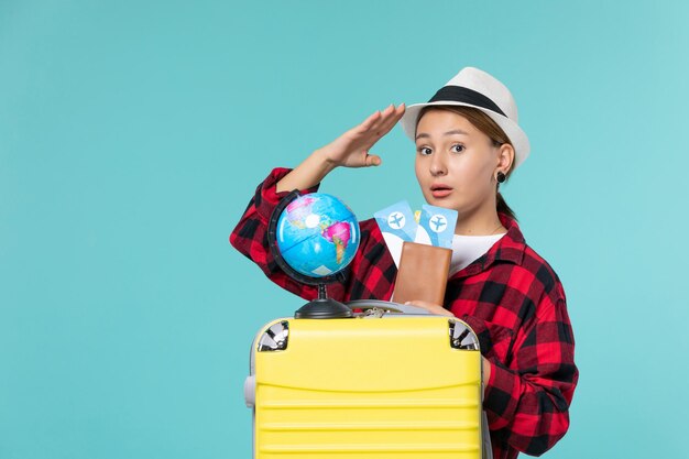 Front view young female holding tickets on a blue space