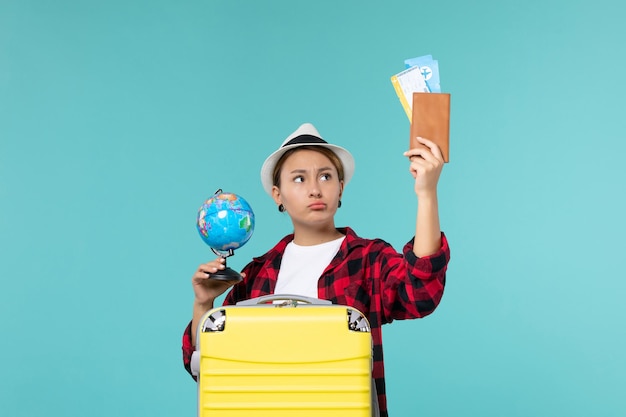 Free photo front view young female holding tickets and globe on a blue space