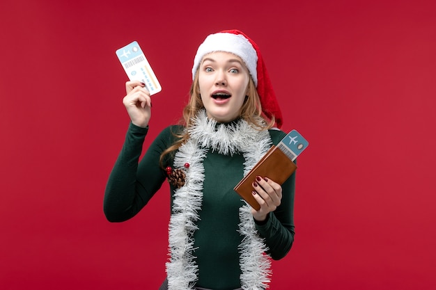 Front view young female holding tickets on a red background