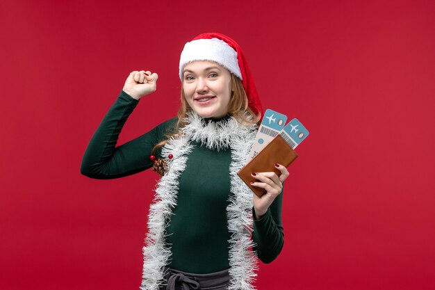 Front view young female holding tickets on a red background