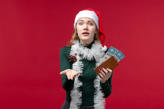 Front view young female holding tickets on a red background