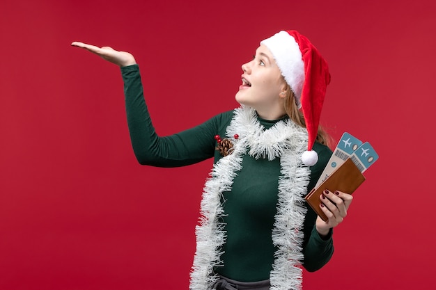 Free photo front view young female holding tickets on red background