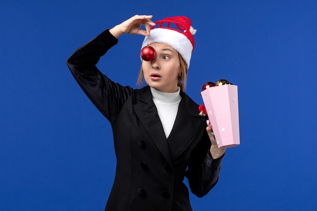 正面図青い背景の青い感情新年の休日に木のおもちゃを保持している若い女性