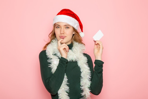 핑크 벽 색상 감정 모델 휴일 크리스마스 새 해에 흰색 은행 카드를 들고 전면보기 젊은 여성