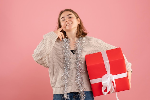 Front view young female holding xmas present smiling