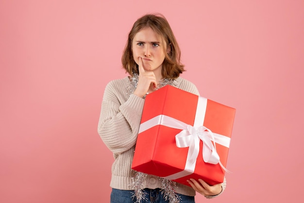 Foto gratuita giovane femmina di vista frontale che tiene pensiero presente di natale