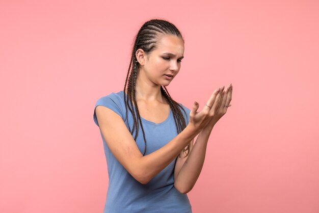 Front view of young female imitating reading on pink