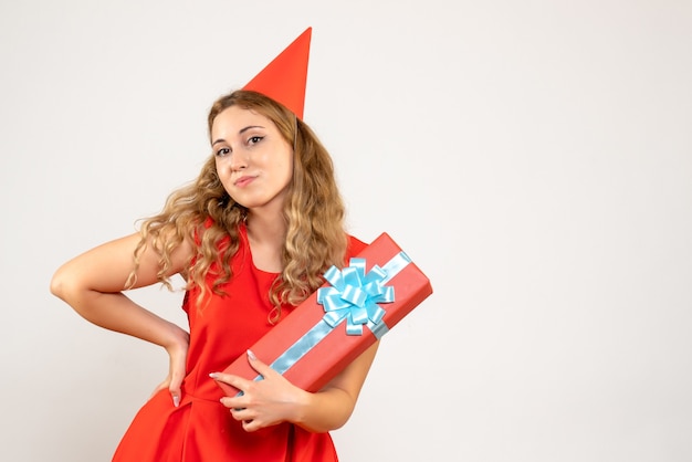 Бесплатное фото Вид спереди молодая женщина в красном платье празднует рождество с подарком