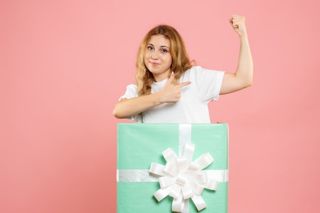 Front view young female inside blue present box flexing