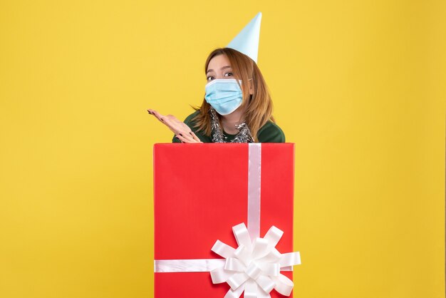 Front view young female inside present box in sterile mask