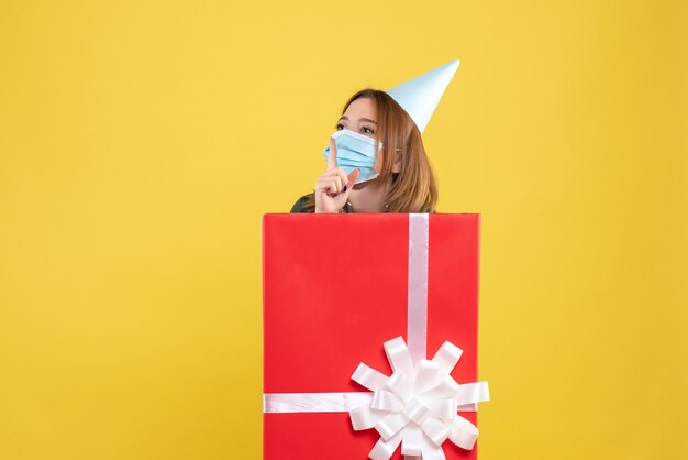 Front view young female inside present box in sterile mask