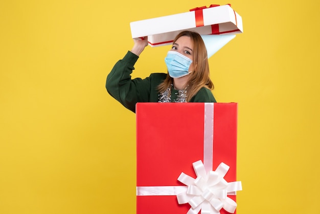 Front view young female inside present box in sterile mask