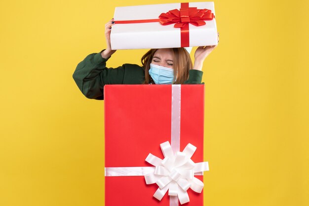 Front view young female inside present box in sterile mask