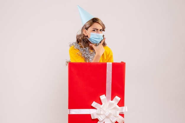 Front view young female inside red present box in mask