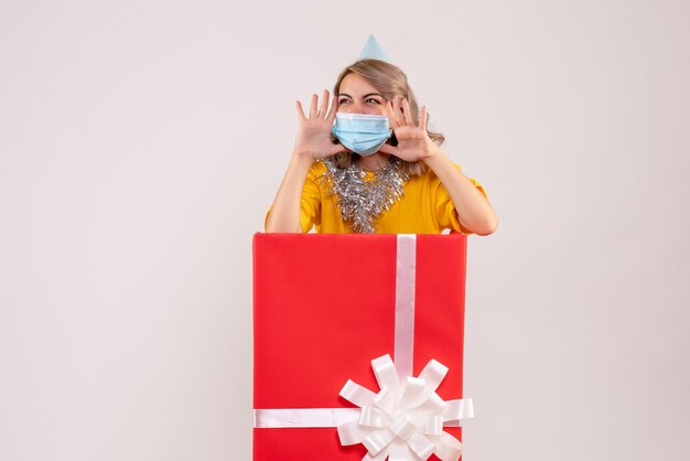 Front view young female inside red present box in mask