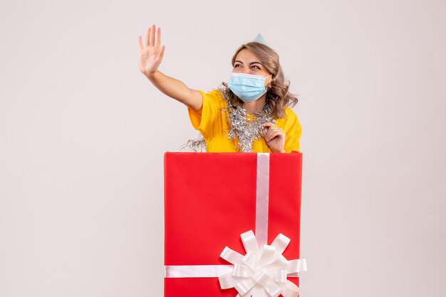 Front view young female inside red present box in mask