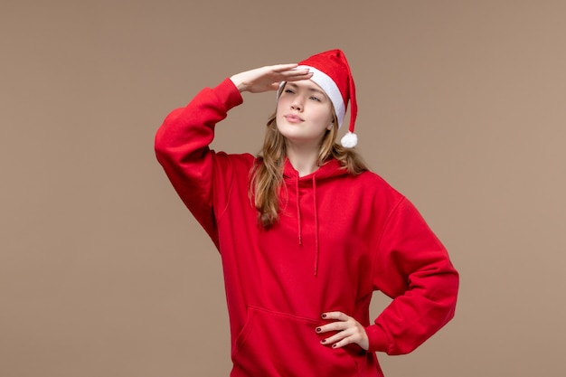 Front view young female looking at distance on brown background christmas emotions holiday