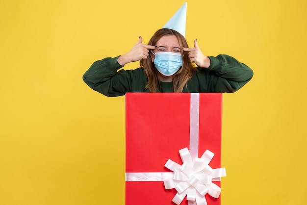 Front view young female in mask inside present box laughing