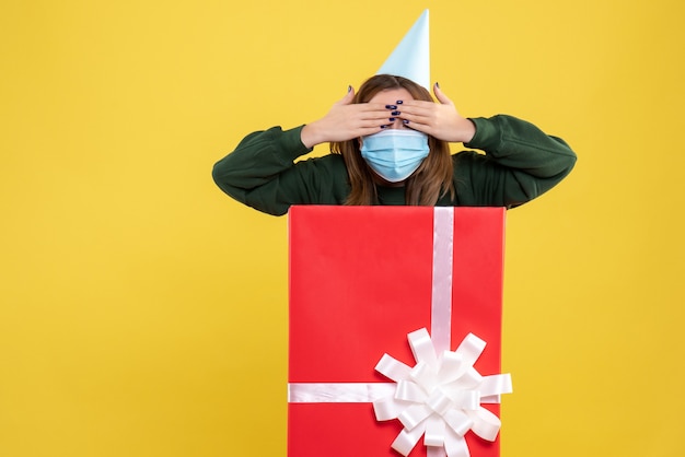 Front view young female in mask inside present box